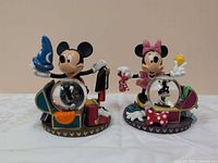 Front view of both Mickey and Minnie figurine snow globes