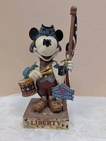 Front view of figurine showing Mickey Mouse with drum, flag, Liberty base