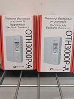 Front view of two boxed Ouellet OTH3000P-A thermostats showing product image and model number
