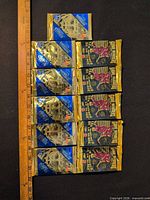Column of mixed blue and black Pinnacle hockey card packs with ruler for scale