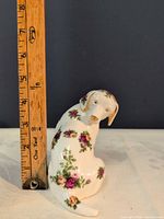 Full view of figurine beside ruler