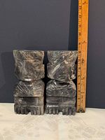 Front view of both soapstone bookends beside ruler showing 8 in height