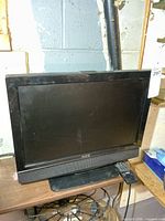 Front view of Aveis TV with remote on table