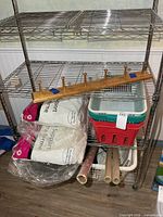 Lot overview showing baskets, pillows, coat rack and gift wrap on shelving