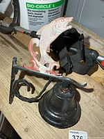 Full view of cast iron bell with fish figure, bracket visible