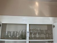 Cabinet shelf with Irish coffee mugs, drinking glasses and plain wine glasses