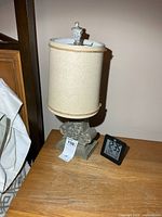 Lamp with shade and clock on bedside table
