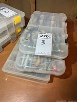 three stacked clear tackle cases filled with fishing lures