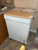 Front angled view of Whirlpool portable dishwasher on casters with wood-look top