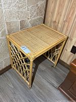 Full view of rattan side table showing woven top and lattice sides