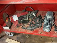 All three power tools and belt pack on shelf