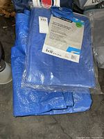 Packaged and loose blue tarps stacked