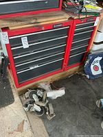 Two Husky red tool cabinets on wood base with detached casters in front