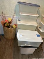 stacked clear totes with lids beside decorative item