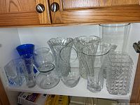 Full shelf view showing all 11 glass vases