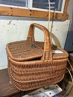 Overall view of wicker picnic basket showing handle and lid