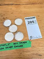 Five coins arranged with lot tag visible