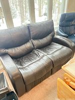 Front angled view of black/brown leather manual reclining loveseat