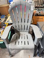 front view of gray plastic Adirondack chair showing slatted back, seat and armrests