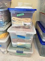 Stacked clear bins with blue lids labeled Backings