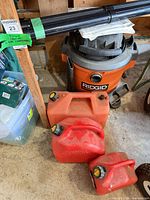 RIDGID vacuum, gas cans, extension wands in garage
