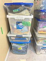 Stack of seven clear Sterilite bins with blue lids labeled Batiks