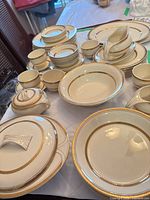 Overview of entire dinnerware set on table showing plates, cups, saucers, serving pieces
