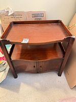 Front view showing overall design with raised lip top, open shelf, cabinet doors