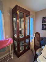 Front view of tall walnut display cabinet with glass doors