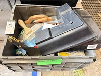 Bin containing plastic mud pan, taping knife, scraper, caulk tubes