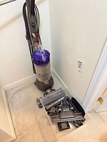 Full view Dyson DC66 vacuum with bin of attachments