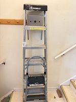 Full view of collapsed Featherlite ladder with Cosco 2-step stool nested inside