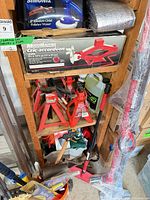 Shelving with boxed scissor jack, polisher, jack stands, pry bar, sledge, container