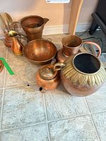 Group shot showing all six mixed-metal vessels on floor