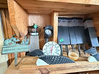 Shelf with Chipmunk sign, wooden loons, coffee grinder, dial thermometer, solar lights, jar candle