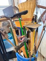 Group of long-handle tools in blue barrel