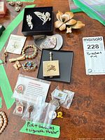 Group shot showing majority of jewelry pieces, badges and cigarette holder