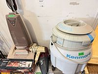 Group shot of Panasonic upright, Kenmore canister, Spillbuster handheld, hair dryer and Spillbuster box