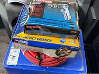 Boxes of Craftsman air drill, Campbell Hausfeld impact wrench and red air hose