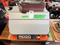 Front view of RIDGID EB44241 belt sander showing RIDGID logo, belt installed, and maxsold lot tag