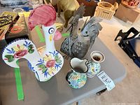 Overview showing ceramic rooster, metal rooster, pitcher, vase