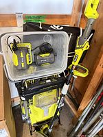 Overall lot showing mower, trimmer, tub with batteries and chargers