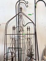 Overall view showing wall trellis and assorted wrought iron hooks