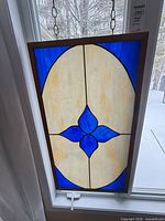 Full view of stained glass panel hanging in window