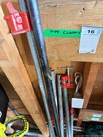 Group of pipe clamps leaning against wall