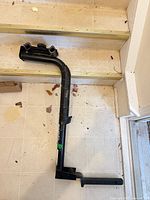 Full view of L-shaped hitch mount carrier arm on floor