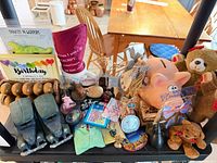 Shelf with assorted items including piggy bank, plush bears, wooden foot massager, cards and small trinkets