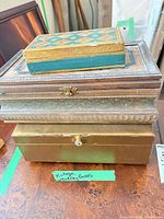 Stack of four vintage jewelry boxes showing sizes, latch, drawer