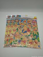 Three sealed sticker sheets stacked