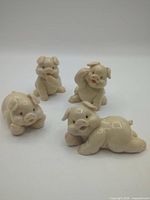 Group shot of four porcelain pig figurines